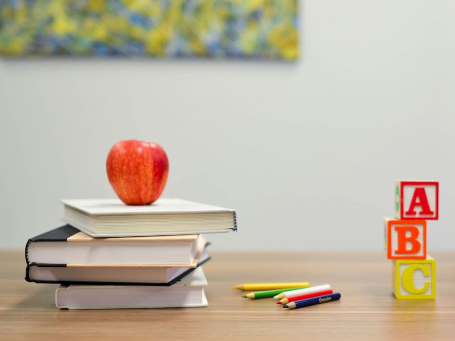Books, an apple, and ABC blocks on a desk